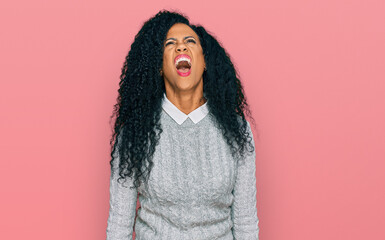 Middle age african american woman wearing casual clothes angry and mad screaming frustrated and furious, shouting with anger. rage and aggressive concept.