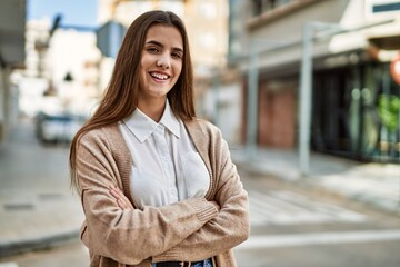 Young hispanic businesswoman smiling happy standing at the city.