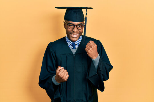 Young african american man wearing graduation cap and ceremony robe celebrating surprised and amazed for success with arms raised and eyes closed. winner concept.