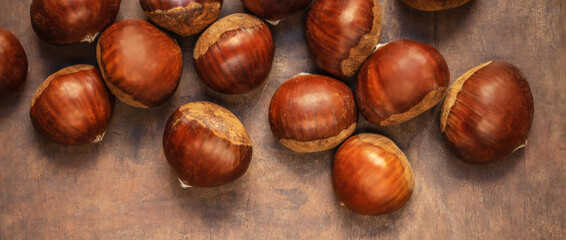Obraz premium Sweet chestnuts on old rustic wooden table with plenty of copy space. Autumn fall concept. Horse chestnuts top view.