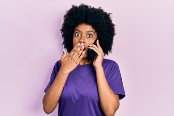 Young african american woman having conversation talking on the smartphone covering mouth with hand, shocked and afraid for mistake. surprised expression