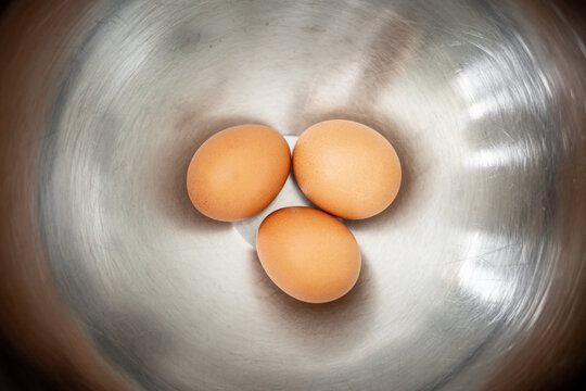 3 oeufs dans un saladier en inox