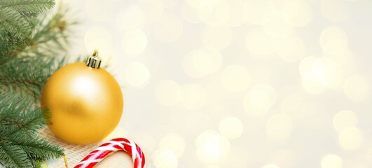 Christmas decoration banner, golden bauble and fir branches on the white background with bokeh lights