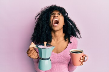 African american woman with afro hair drinking italian coffee angry and mad screaming frustrated and furious, shouting with anger looking up.