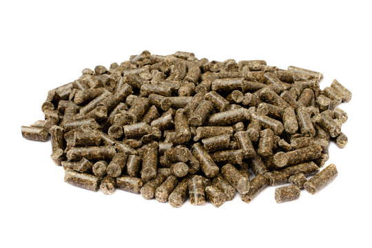 Sunflower granulated feed isolated on white background, close-up. Pile of sunflower meal pellets isolated on white background. Heap of animal feed pellets isolated on white background.