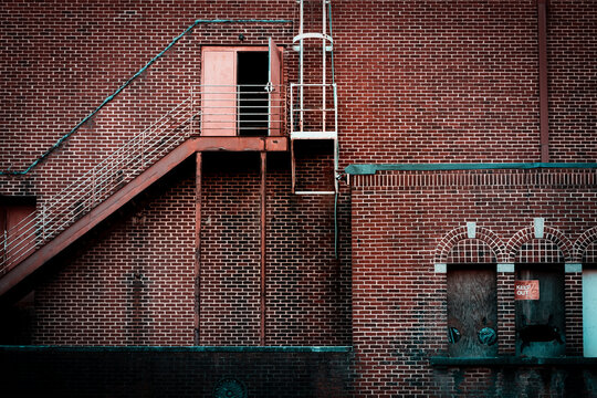 Iron fire escape and birck facade with teal trim and keep out sign