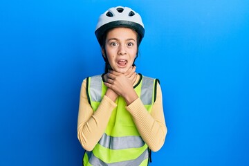 Beautiful brunette little girl wearing bike helmet and reflective vest shouting and suffocate because painful strangle. health problem. asphyxiate and suicide concept.