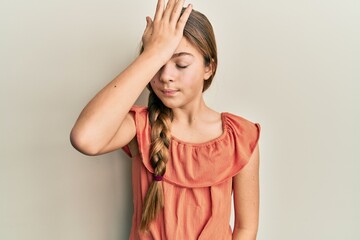 Beautiful brunette little girl wearing summer shirt surprised with hand on head for mistake, remember error. forgot, bad memory concept.