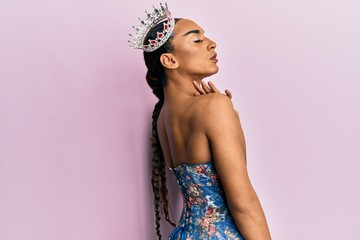 Sensual hispanic transgender woman wearing queen crown and posing glamorous with seductive face...