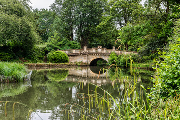 Fototapeta na wymiar The lake and bridge in Pittville Park in Cheltenham in Gloucestershire, England