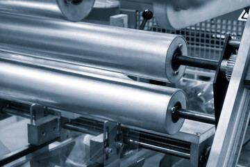 The operation of automatic plastic bag production machine with lighting effect. Close-up of the...