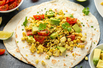 Scrambled Tofu Tacos with avocado, tomatoes and green herbs. Healthy Vegan Breakfast.