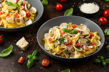 White shell clams in Garlic and parsley white wine sauce tagliatelle pasta served with cherry tomatoes and parmesan cheese