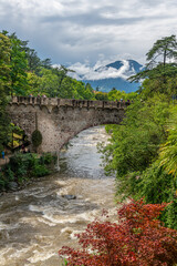 Fototapeta na wymiar View of the famous Steinerner Steg - Ponte Romano bridge, a two-arched, stone-built footbridge across the Passer in Merano, South Tyrol, northern Italy.
