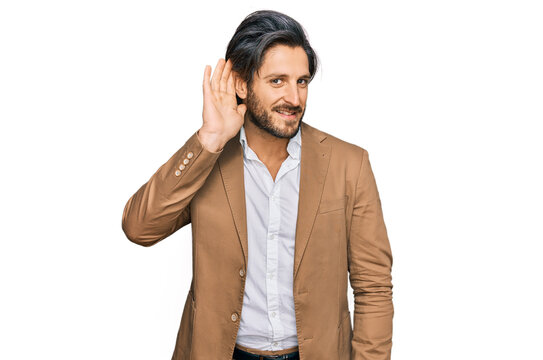 Young hispanic man wearing business clothes smiling with hand over ear listening an hearing to rumor or gossip. deafness concept.