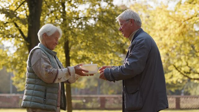 Charity and social welfare. Volunteer man giving a hot meal to an elderly woman. High quality 4k footage