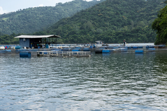 Dramatic image of a tilapia farm on a reservoir high in the Caribbean mountains of the Dominican Republic. With boats and docks.