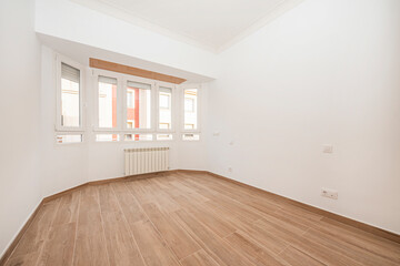 White painted room with stoneware floor like wood with curved window and aluminum radiator