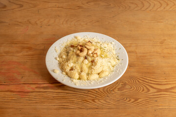 Italian gnocchi recipe with grated cheese and dried fruits, cashews, peanuts and raisins with oregano