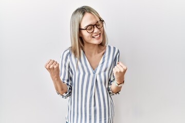 Asian young woman wearing casual clothes and glasses very happy and excited doing winner gesture with arms raised, smiling and screaming for success. celebration concept.