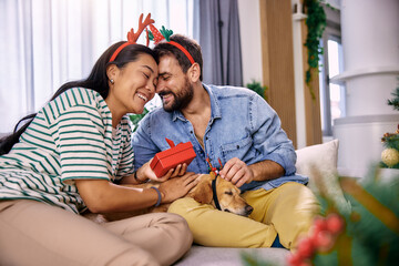 Christmas gifts and happiness between a young couple and a cute dog