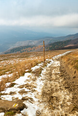 Muddy hiking trail in Bieszczady Mountains in Poland. Late autumn and first snow. 