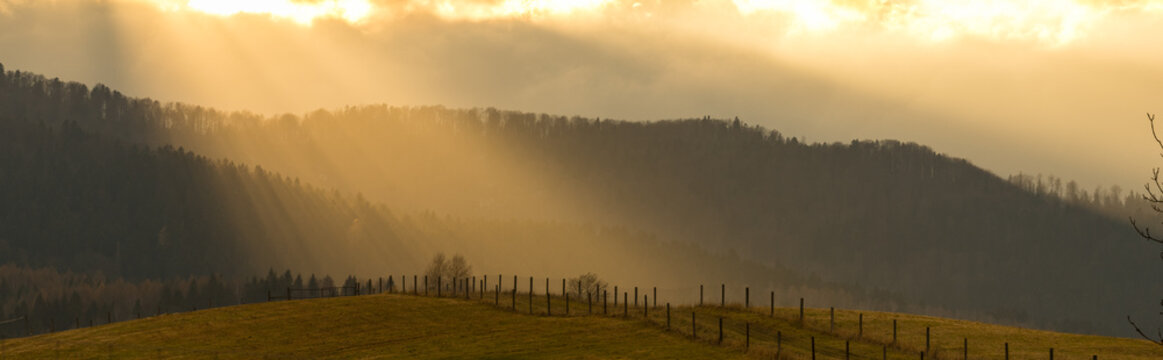 Rays of the sun on a misty morning in the Bieszczady Mountains on the Polish-Ukrainian border. Late fall.