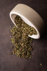 selective focus, natural green leaf tea. brewing in a clay bowl. vertical angle, macro. on a dark background. for menus and cafes