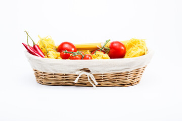 horizontal shot Basket with spaghetti, tagliatelle, red hot chilli pappers and cherry tomatoes, tomatoes