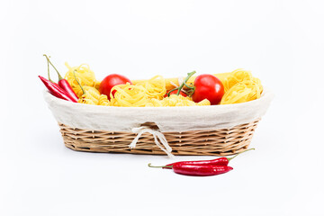 Basket with spaghetti, tagliatelle and cherry tomatoes, tomatoes, red hot chilli pappers