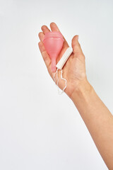 silicone pink menstrual cup, hygienic tampon in female hand on white background