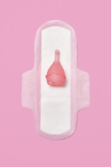 cotton sanitary pad napkin, silicone pink menstrual cup on pink background
