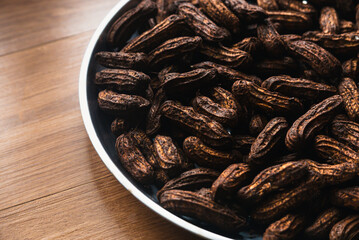 A groundnuts still covered with soil on wooden background.