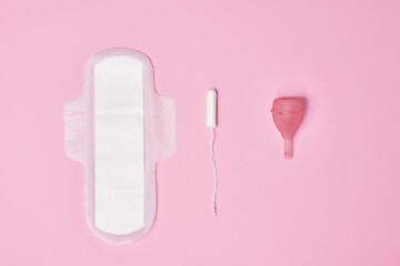 hygienic feminine tampon for menstruation, menstrual cup, pad on pink background