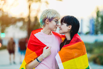 Portrait of a gender fluid couple wearing rainbow flag
