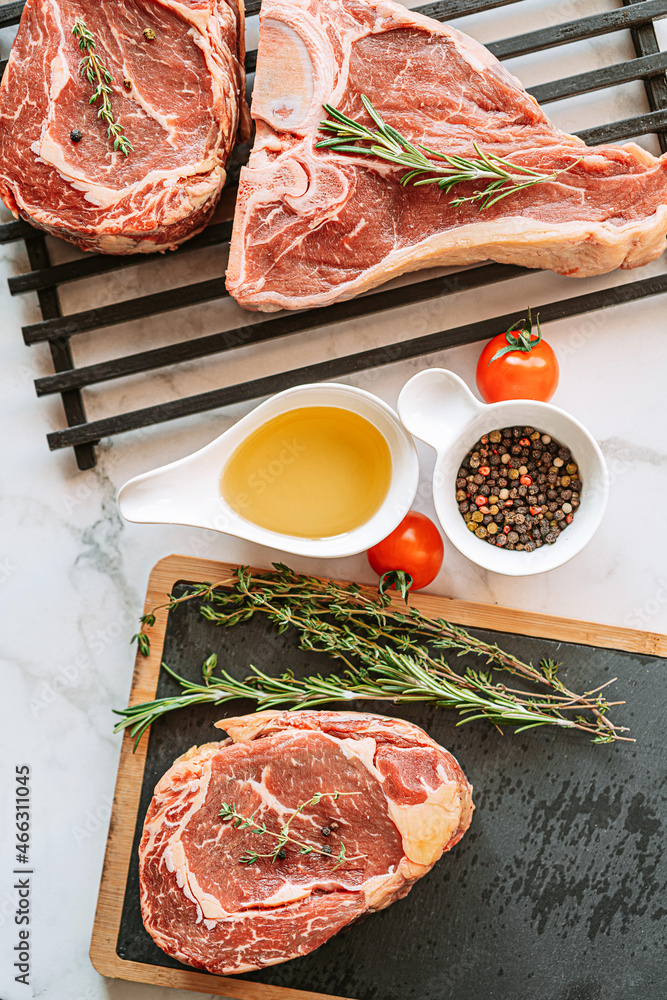 Wall mural three delicious steaks ready to grill on a white marble surface