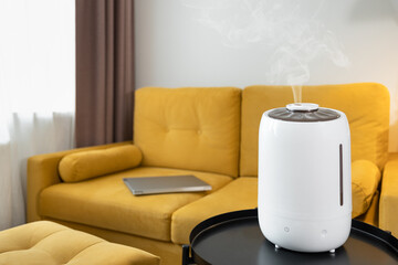 White air humidifier spreading steam. Humidification of dry air in living room. Selective focus on...