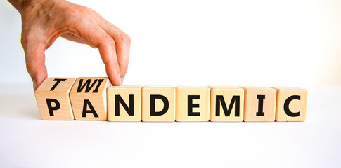 Pandemic or twindemic symbol. Doctor turns wooden cubes and changes the word 'pandemic' to...