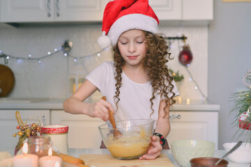 Girl is cooking christmas cookies. She is in the kitchen at home. Horizontal frame. She is looking at dough.