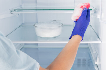 close-up of cleaning the shelves with detergent in the refrigerator