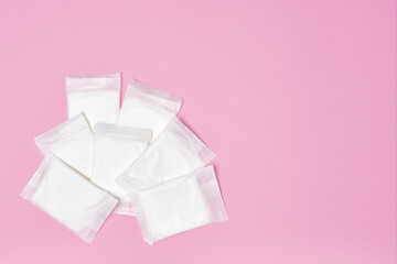 packaged cotton sanitary pad napkin on pink background, copy space