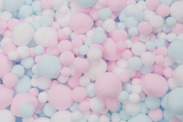 White, pink and blue soft pompons as a background.