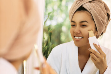 Cleansing facial skin, remove face blackheads. Asian woman looking at reflection in the mirror...