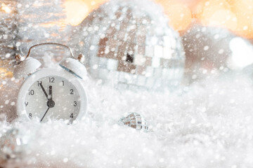 Beautiful background with clocks, sequins, balls and decorations. Countdown to midnight. The hours of the last moments before the New Year 2022. Celebrating the winter Christmas holidays.