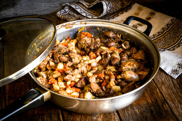 Fried chicken liver in a frying pan on the kitchen table. Home cooking in the village.