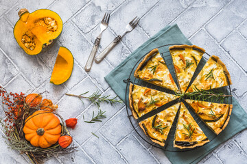 Pumpkin tart with rosemary on a slate plate on gray background, top view