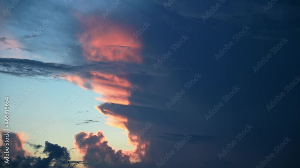 Wall mural timelapse of sky with weather changing from peaceful sunset into storm with lightning visible in the