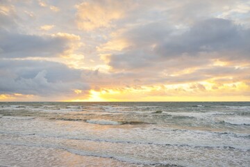 Panoramic view from the Baltic sea shore at sunset. Dramatic cloudscape, glowing clouds, golden...