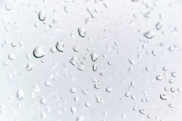 Raindrops on a window pane with a cloudy, rainy day and gray clouds, in Madrid, Spain. Europe. Horizontal photography.