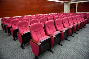 Empty hall for presentation with red armchairs.